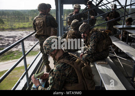 Marines give coordinates for a fire mission on Observation Post Five at Camp Lejeune, N.C., April 20, 2017. The Marines participated in the Marine Corps Combat Readiness Evaluation to show they were ready for their upcoming deployment with the 26th Marine Expeditionary Unit. The Marines are with 2nd Battalion, 10th Marine Regiment. Stock Photo