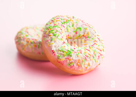 Sweet sprinkled donuts on pink background. Stock Photo