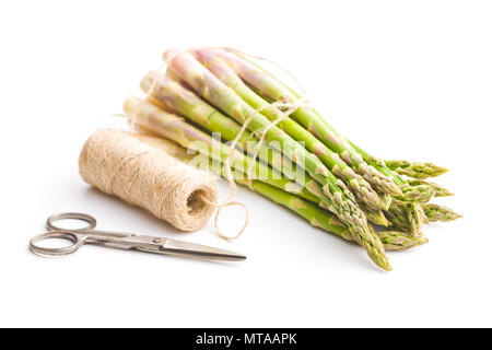 Fresh green asparagus with scissors and thread isolated on white background. Stock Photo