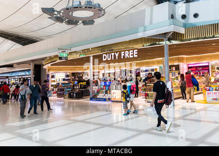 People walking past the duty free sales shop, Bangkok airport, Thailand Stock Photo