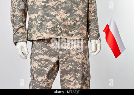 Dummy in army camouflage uniform with poland flag. Patriotic soldier mannequin. White isolated background. Stock Photo