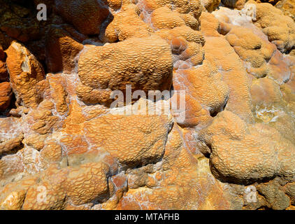 Close up. Stones covered with natural radon spring sediment. Beautiful texture in yellow, red and green colors. Stock Photo