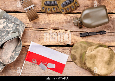 Military essentials arrangement f polish soldier. Flat lay, top view. Army items on wood. Stock Photo