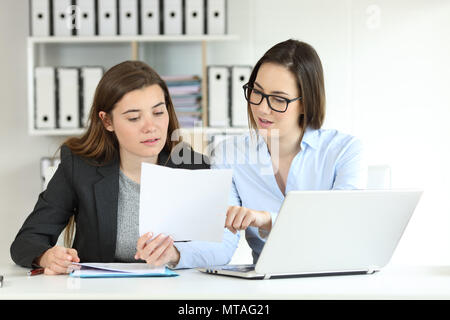 Two concentrated office workers coworking comparing documents Stock Photo