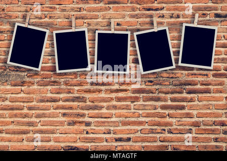 Five instant photo hanging on old brick wall background and texture with space. Stock Photo