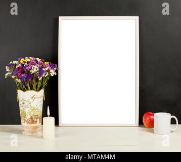 Silver frame mockup with field flowers in vase, apple, mug and candle. Empty frame mock up for presentation design. Template framing for modern art. Stock Photo