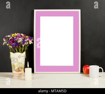 Fame mockup with field flowers in vase, apple, mug and candle. Empty frame mock up for presentation design. Template framing for modern art. Stock Photo
