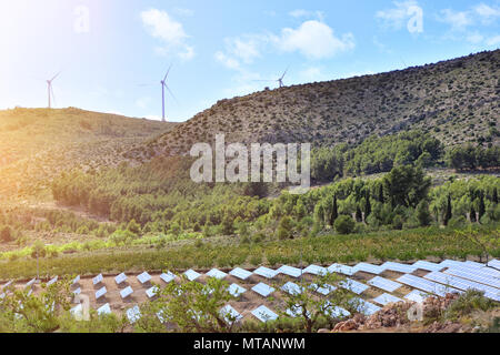 Landscape with installation of renewable energies. Solar panels and electric wind generators. Stock Photo