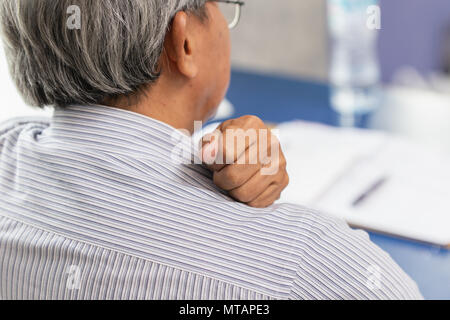 Asian Elderly back neck and shoulder pain using hand to massage and rub. Stock Photo