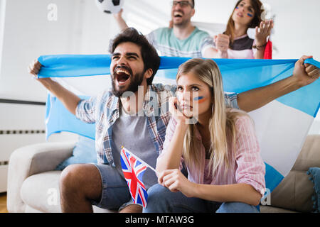 Happy and sad friends or football fans watching soccer game Stock Photo
