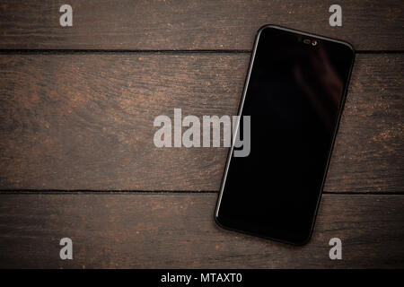 Black smartphone on a wooden table Stock Photo