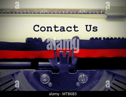 Contact us text written by an old typewriter on white sheet Stock Photo