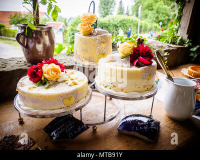 White wedding cake and sweets decorated with natural flowers Stock Photo