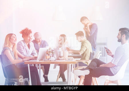 Multicultural team of coworkers having a good time at work Stock Photo