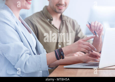 Two colleagues working on a project using a laptop Stock Photo