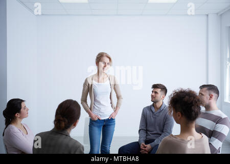 Woman talking about her life during group therapy Stock Photo
