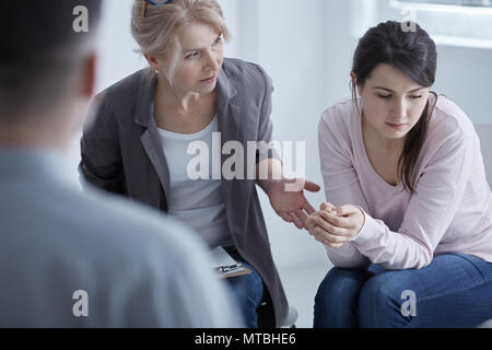 Psychotherapist supporting young woman suffering from depression Stock Photo