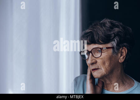 Sad, lonely senior woman suffering from depression Stock Photo
