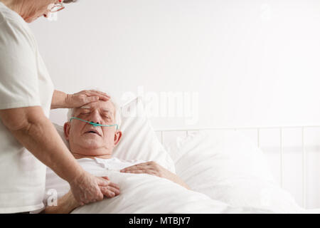 Loving husband caring for sick wife in bed Stock Photo - Alamy