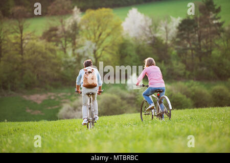 Beautiful senior couple with bicycles cycling outside in spring nature.