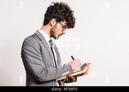 Portrait of a young man with a notepad in a studio on a white background. Stock Photo