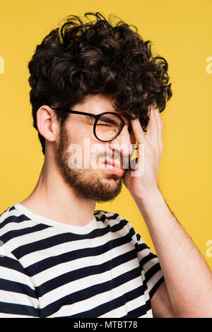 Studio portrait of a young man on a yellow background. Stock Photo