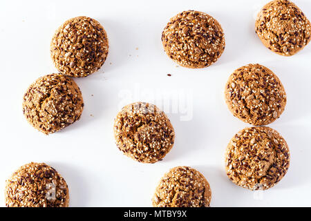 freshly baked oatmeal cookies sprinkled with sunflower seeds, linseed and sesame seeds. healthy pastries on a white background Stock Photo