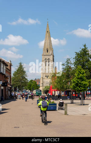 Cyclist in high vis jacket and People enjoying the sun in The Market square. Market Harborough, a Market town in Leicestershire, England Stock Photo