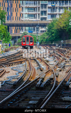 A Trains departs from White City London Underground Station navigating an array of different points and lines. Stock Photo