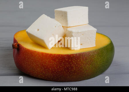 cubes of marshmelow on a gray background, next to avocado Stock Photo