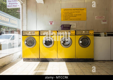 A beautiful yellow coin-op Launderette in central London, UK Stock Photo