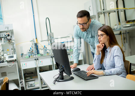 Side view of focused students using desktop pc in classroom at Technical faculty Stock Photo