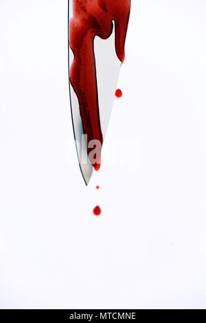 Sharp metal kitchen knife with blood dripping from its edge in a vertical shot Stock Photo