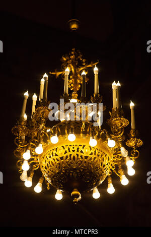 Big chandelier with energy saving bulbs at cathedral at dark Stock Photo