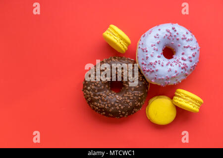Seamless pattern made of macaroon and donut on the red background. Flat lay. Food concept. Unhealthy dessert. tasty sweet morning. Donuts and french delicious cakes isolated Stock Photo