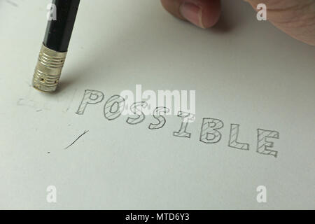 Changing the word impossible to possible with a pencil eraser, closeup Stock Photo
