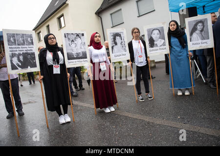 Solingen, Germany. 29 May 2018. Young women carry pictures of the victims at the place of the arson attack. 25 years after the racially motivated arson attack of Solingen, the victims are honoured with two events. In the night of 29 May 1993, four right-wing extremists set fire to the house of the Turkish family Genc in North Rhine-Westphalia. Credit: dpa picture alliance/Alamy Live News Stock Photo