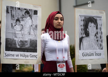 Solingen, Germany. 29 May 2018. A young woman carries pictures of the victims at the place of the arson attack. 25 years after the racially motivated arson attack of Solingen, the victims are honoured with two events. In the night of 29 May 1993, four right-wing extremists set fire to the house of the Turkish family Genc in North Rhine-Westphalia. Credit: dpa picture alliance/Alamy Live News Stock Photo