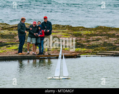 Milsey Bay, North Berwick. East Lothian, Scotland, United Kingdom, 30th May 2018. People having fun playing with radio controlled Kyosho Marine Racing sailing yacht in the tidal bathing pool Stock Photo