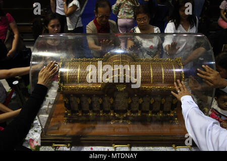 Catholic devotees seen touching the Shrine of Saint Therese of the Child Jesus in New Port City in Pasay, Metro Manila, for the veneration of  the holy relic of Saint Therese of Lisieux. The reliquary containing the bones of Saint Therese has been on a nation wide tour and is on its last few days in Manila before heading back to France. Stock Photo
