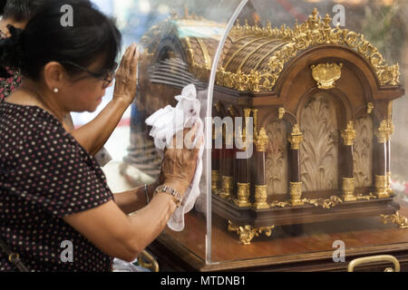 Catholic devotees seen touching the Shrine of Saint Therese of the Child Jesus in New Port City in Pasay, Metro Manila, for the veneration of  the holy relic of Saint Therese of Lisieux. The reliquary containing the bones of Saint Therese has been on a nation wide tour and is on its last few days in Manila before heading back to France. Stock Photo