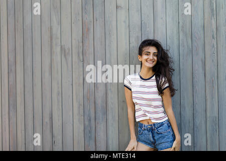 Beautiful brunette woman posing outdoors, looking at camera Stock Photo