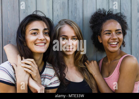 Three beautiful smiling women standing together, outdoor shot Stock Photo