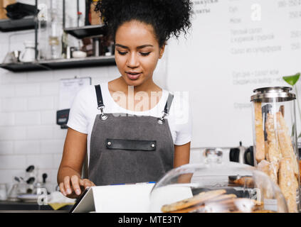 Young businesswoman makes an order for her cafeteria, using digital tablet Stock Photo
