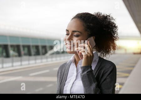 Young woman talking on mobile phone with her eyes closed Stock Photo