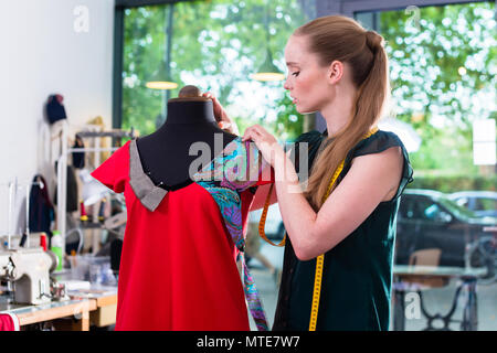 Fashion designer draping dress on mannequin Stock Photo