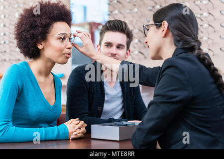 Optician showing woman new glasses Stock Photo