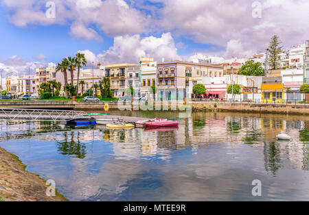 Traditional white architecture of the region along the riverbank in Ayamonte, Huelva province, Andalucia, Spain.  There are pleasure paddle boats on r Stock Photo