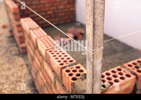 Brick wall in construction with string line across top edge Stock