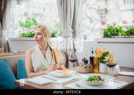 young woman waiting someone who late, and looking for her boyfriend in coffee shop. Portrait of young unhappy stressed beautiful female sitting in mod Stock Photo